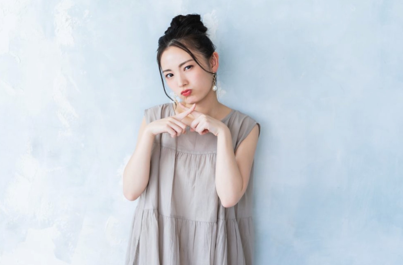 ✕マークを作る女性